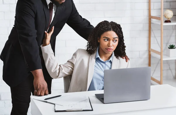 Az afro-amerikai főnök szexuálisan zaklatja a női beosztottját az irodában. — Stock Fotó
