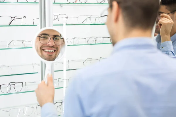 Uomo felice che sceglie occhiali al negozio di ottica — Foto Stock