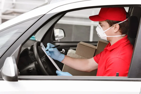 Pengiriman cepat dengan kurir di rumah. Man in car checks data to boxes — Stok Foto