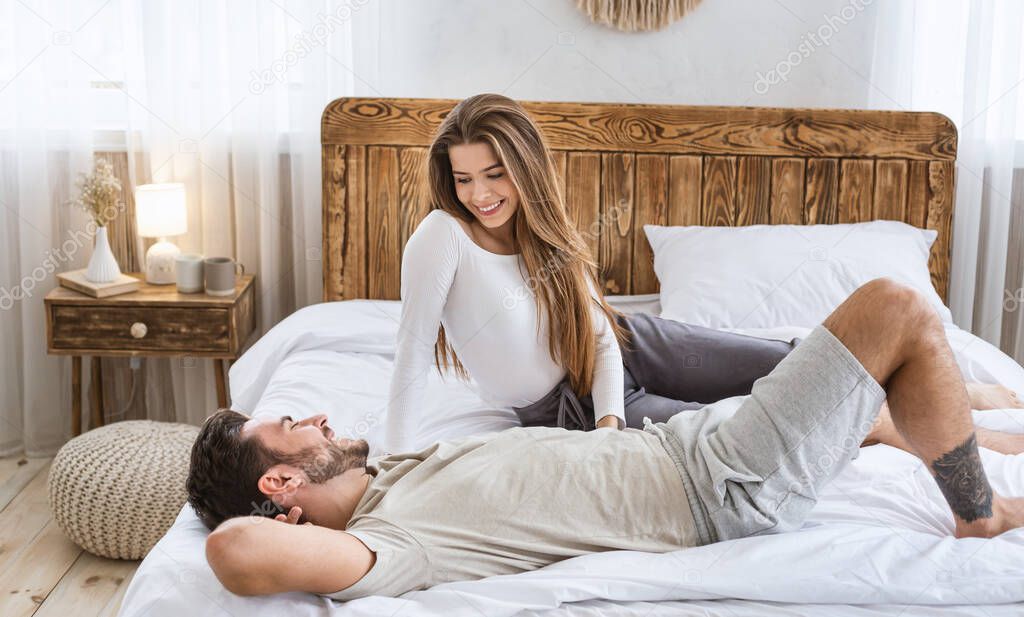 Man and woman talking in bed in bedroom interior