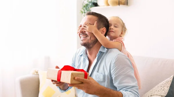 Ragazza eccitata che tiene il suo regalo con papà — Foto Stock