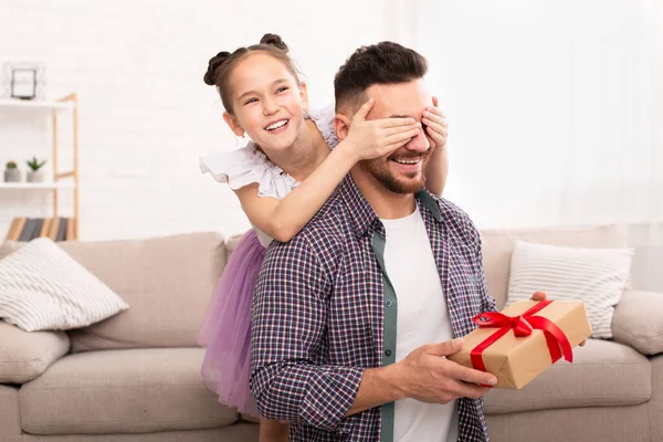 Brincalhão filha surpreendendo seu pai, fechando os olhos e dando presente — Fotografia de Stock