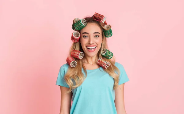 Feliz conceito de dona de casa. Rindo menina com encrespadores de cabelo — Fotografia de Stock