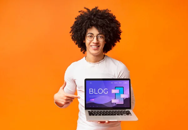 Funky Αφροαμερικανός τύπος δείχνει στην οθόνη του υπολογιστή με ιστοσελίδα blog, πορτοκαλί φόντο. Κολάζ — Φωτογραφία Αρχείου