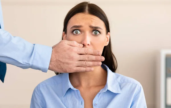 Empresário que cobre a boca assustada das mulheres fazendo-a manter o silêncio interior — Fotografia de Stock