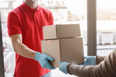 Kurye eve tıbbi eldivenlerle paket getiriyor.