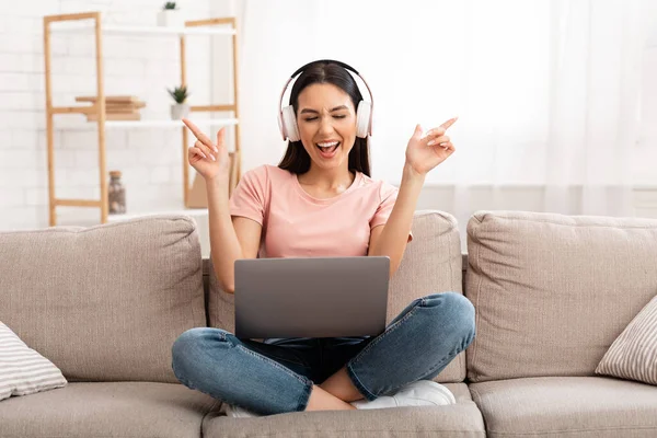 Mädchen hört Musik über Kopfhörer auf Couch — Stockfoto