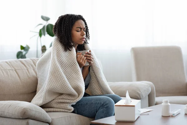 Άρρωστη μαύρη γυναίκα που υποφέρει από γρίπη στο σπίτι, πίνοντας τσάι και αναπαύοντας — Φωτογραφία Αρχείου