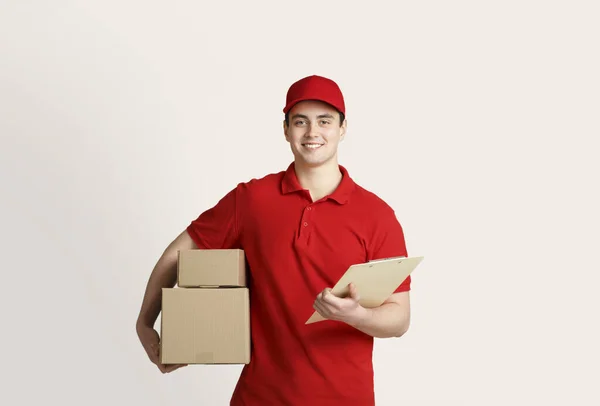 Lieferung nach Hause mit Kurier. Zusteller hält Kartons und Tablet in der Hand — Stockfoto