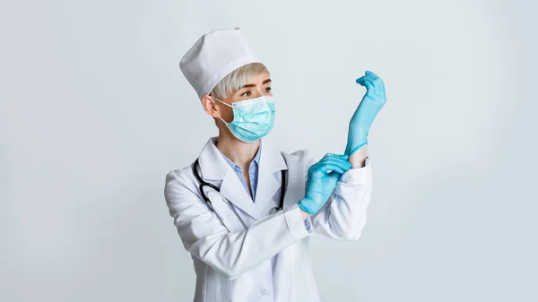 医者は患者を調べる用意ができている。女性は保護マスクと手袋を着る — ストック写真