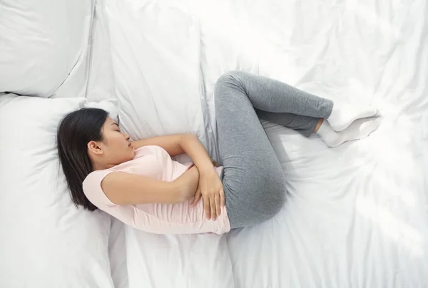 Asian Woman Sleeping Having Abdominal Pain At Home, Above View — Stock Photo, Image