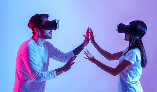 Miłość i nowoczesna technologia. Para w wirtualnych okularach dotyka się dłońmi — Zdjęcie stockowe