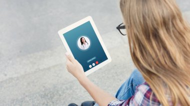 Woman having video chat with male doctor using tablet clipart