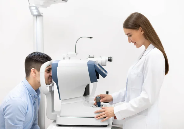 Optometrista revisando la visión de los pacientes en clínica moderna —  Fotos de Stock