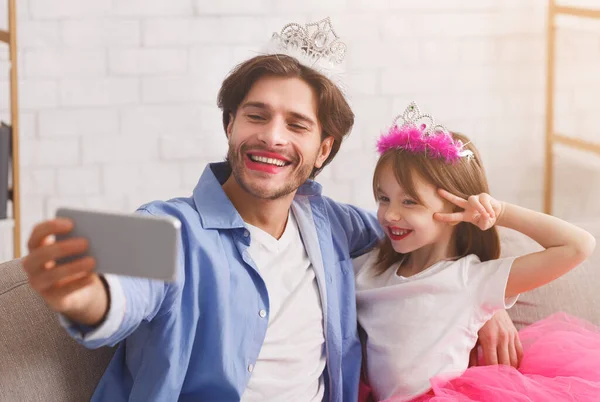 Mutlu baba ve kız prensesler gibi giyinip selfie çekiyorlar.