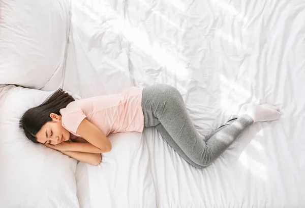 Číňanka spí v posteli doma, pohled shora — Stock fotografie