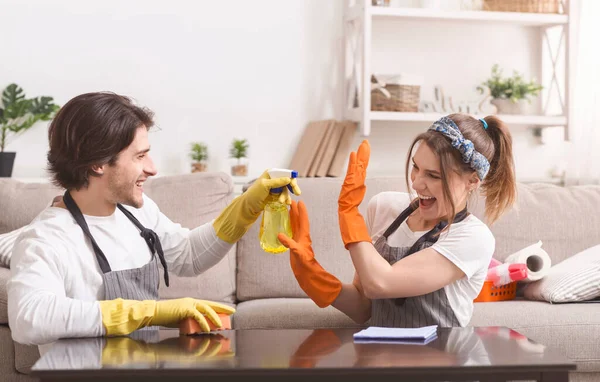 Jong paar gek terwijl het opruimen van platte samen, man spuiten water bij vriendin — Stockfoto