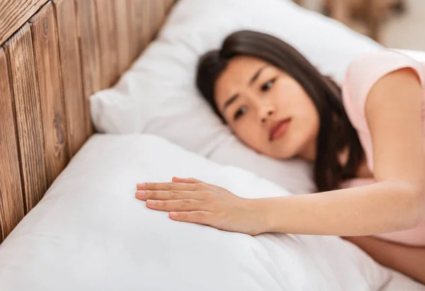 Asiatico donna toccando cuscino sdraiato in letto da solo dopo rottura — Foto Stock