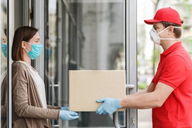 Covid-19 konsepti sırasında eve teslimat. Müşteri kuryeden büyük bir karton kutu alır..