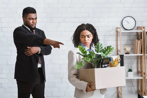 Kris och arbetslöshet. Grymt afroamerikansk chef avskeda sin sorgliga kvinnliga anställd från företagets kontor — Stockfoto