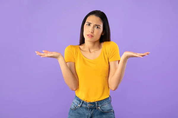 Confuso perplesso giovane donna scrollando le spalle in studio — Foto Stock