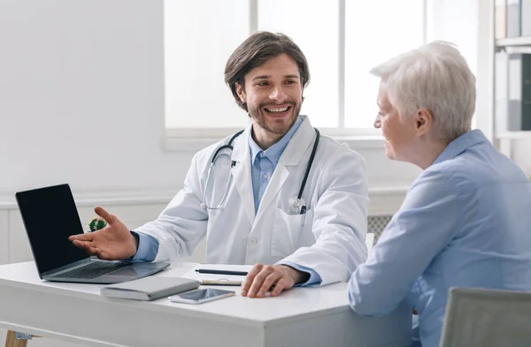 Geriatra explicando los resultados de la prueba al paciente mayor en la computadora portátil — Foto de Stock