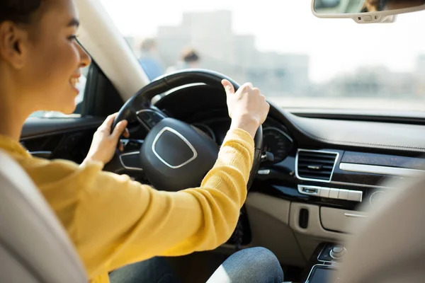 Conductor femenino feliz que conduce el coche que monta en ciudad — Foto de Stock