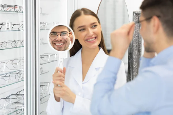 Оптометрист допомагає людині вибирати корекційні окуляри — стокове фото