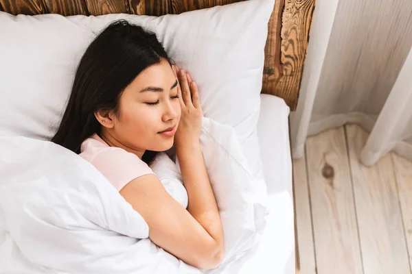 Japonesa mujer durmiendo acostada en cómoda cama descansando en el dormitorio —  Fotos de Stock