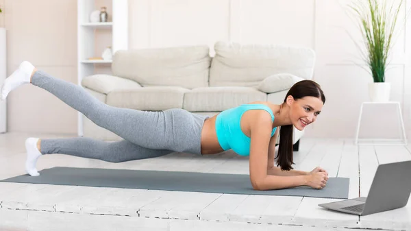फिटनेस महिला घर पर लैपटॉप पर ऑनलाइन प्रशिक्षण देख रही व्यायाम — स्टॉक फ़ोटो, इमेज