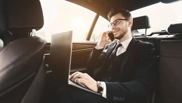젊은 사업가가 pc 를 사용하여 자동차로 통화하는 모습 — 스톡 사진