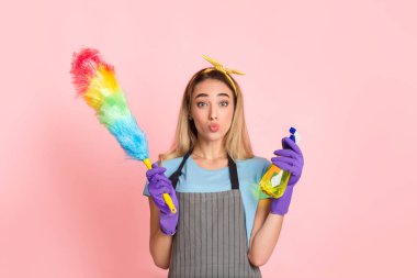 Cleaning at home concept. Housewife makes blowing kiss and holds brush and spray clipart