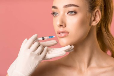 Pretty Girl Receiving Beauty Injection In Lips Over Pink Background