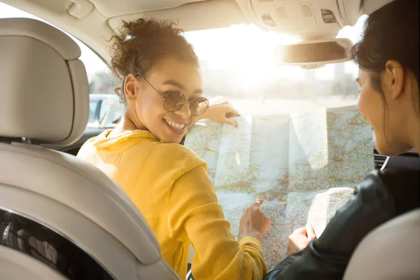 Glada flickor vänner tittar på Road Map Sitter i Automobile — Stockfoto