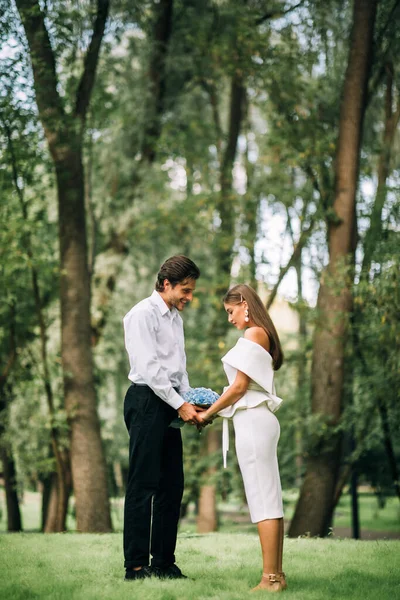 Novia y novio en amor sosteniendo las manos de pie en el parque — Foto de Stock