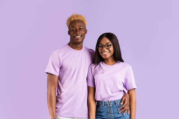 Ung svart kille med sin flickvän i glasögon ler på syren bakgrund — Stockfoto