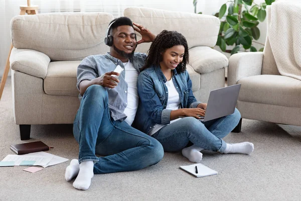 Black Millennial casal relaxando juntos em casa com seus dispositivos eletrônicos — Fotografia de Stock