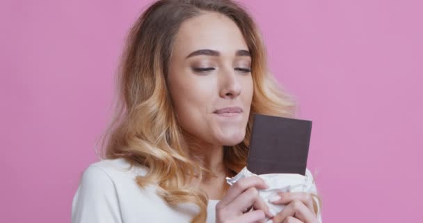Mulher agradável desfrutando de chocolate com olhos fechados — Vídeo de Stock