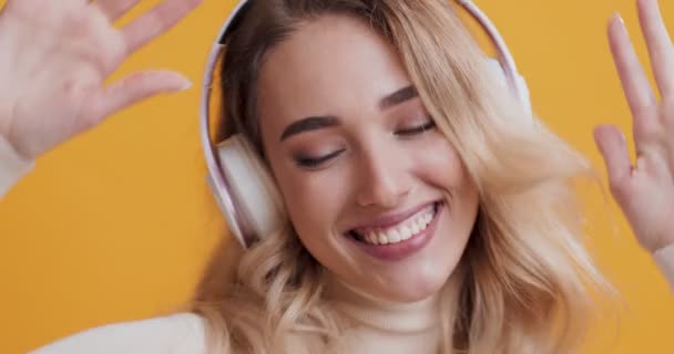 Mujer alegre escuchando música en auriculares y bailando — Vídeos de Stock