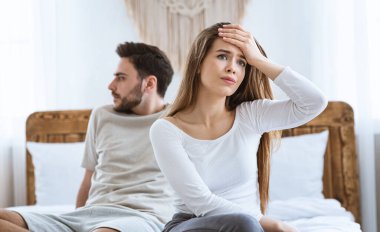 Saldırgan eşler yatak odasında, yatakta otururken birbirlerine sırtlarını döndüler.