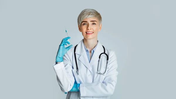 Prick concept. Doctor in white coat and rubber gloves with syringe in hand — Stock Photo, Image