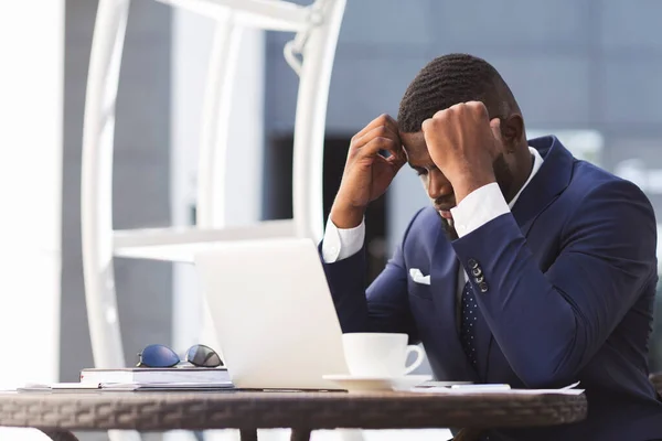 Depressieve zakenman zit achter laptop in café leest slecht nieuws — Stockfoto