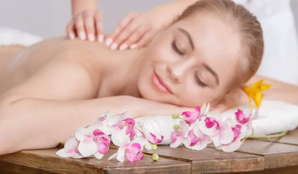 Prazer de tratamentos de spa. As mãos femininas fazem massagem relaxante para mulher com olhos fechados — Fotografia de Stock
