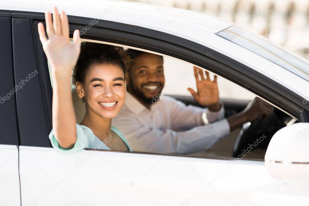Happy African American Couple Waving Good Bye Sitting In Auto
