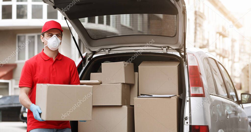 Courier in protective mask and gloves get boxes from the car, outdoor