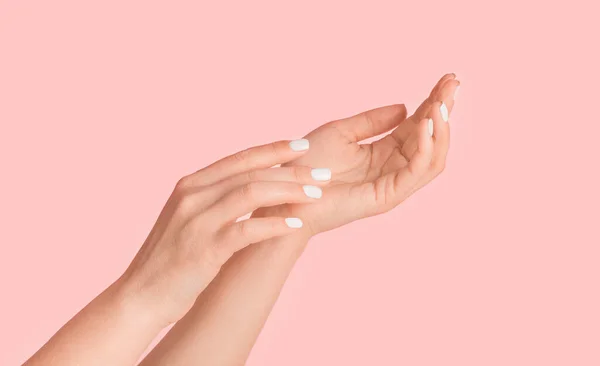 Jovem mostrando as mãos com pele sedosa e manicure perfeito no fundo rosa, close up. Panorama — Fotografia de Stock