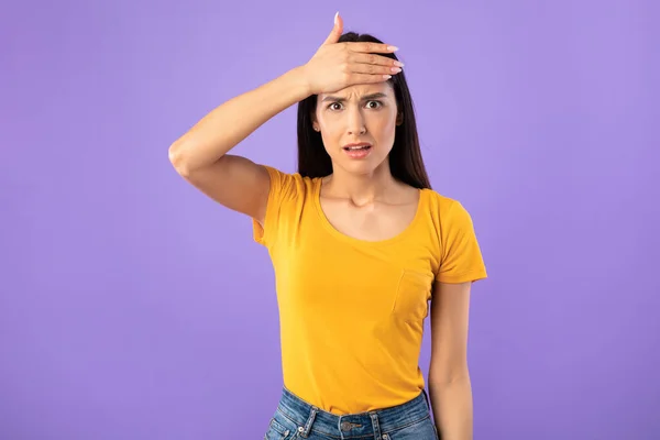 Confuso confundido jovem mulher tocando cabeça no estúdio — Fotografia de Stock