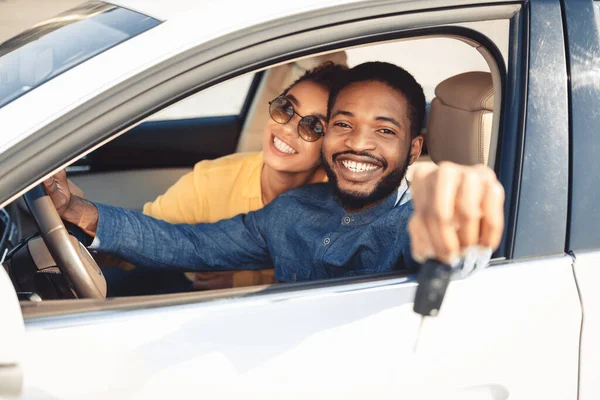 Cônjuges afro-americanos mostrando novo carro chave sentado no automóvel — Fotografia de Stock