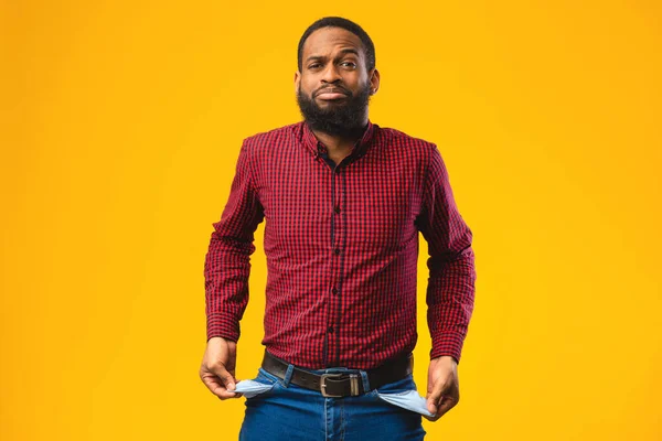 Portrait of black guy showing empty pockets — Stock Photo, Image