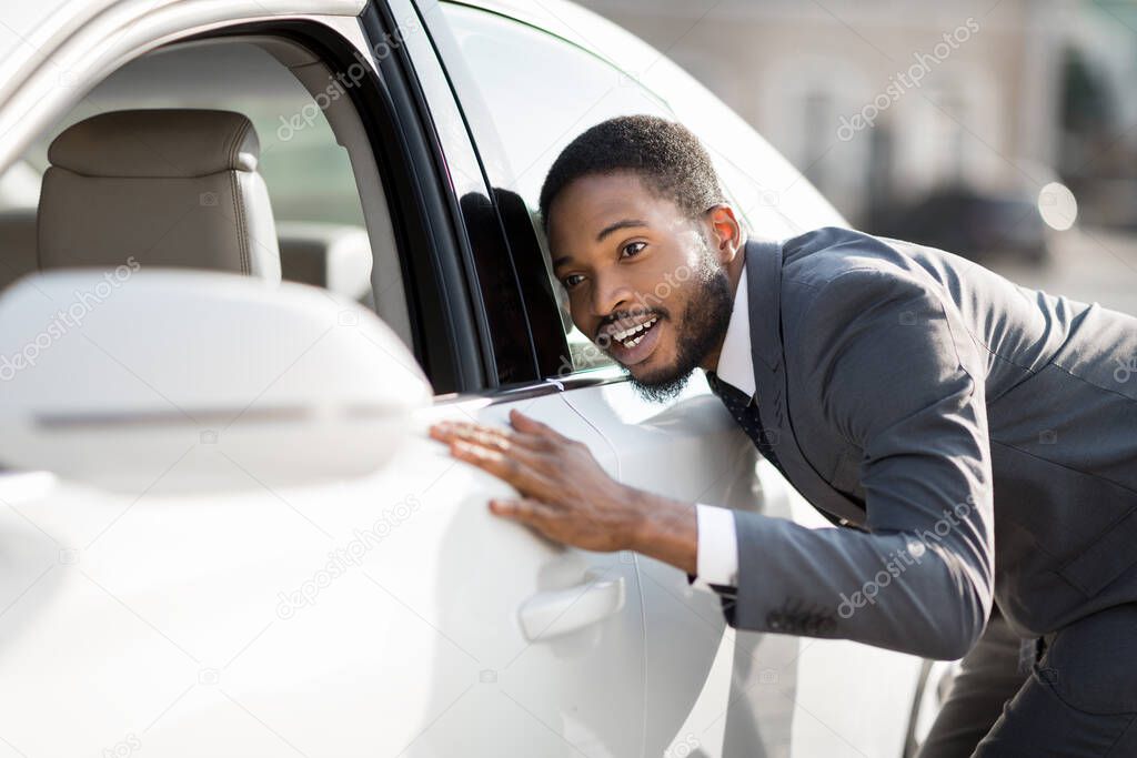 Black Businessman Checking And Touching His New Automobile Outside